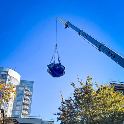 A crane lifting a load of construction debris using a StrongSling. A crane lifting a load of construction debris using a StrongSling.