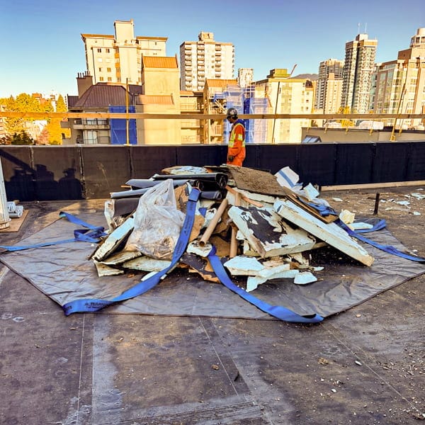 StrongSling loading with a large pile of construction debris on a rooftop jobsite. StrongSling loading with a large pile of construction debris on a rooftop jobsite.